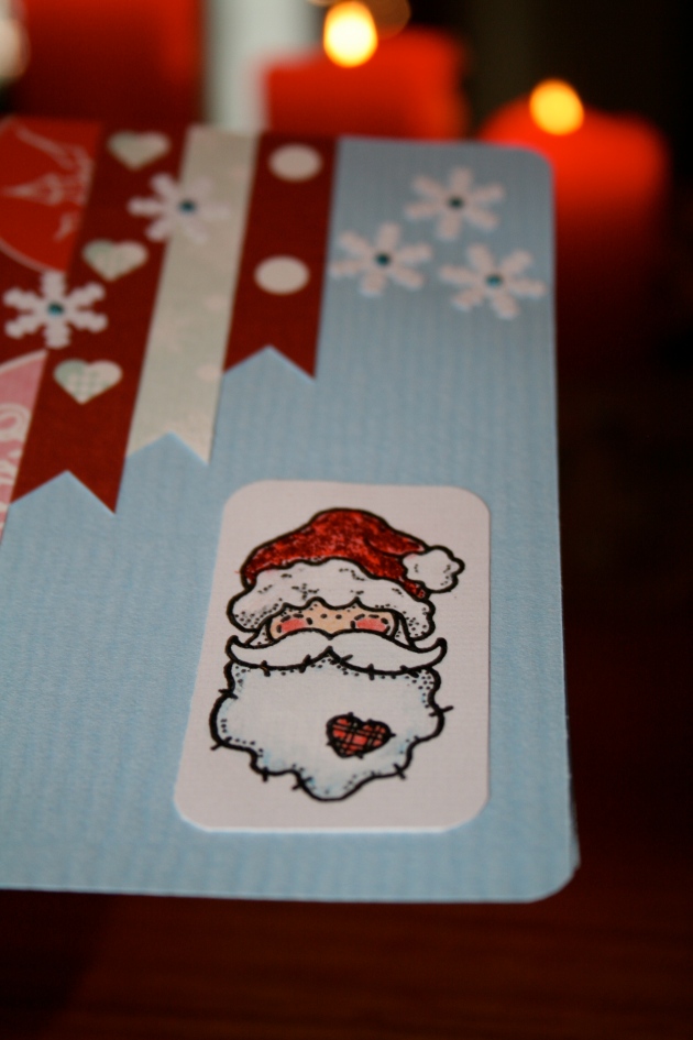 Julkort 2013 - ljusblått kort med pappersremsor och snöflingor och tomte (närbild på tomte)